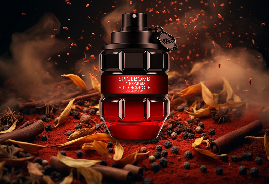 در این عکس، عطر مردانه ویکتور اند رولف که شیشهی آن مشکی قرمز و به شکل نارنجک است همراه با زعفران و دانههای فلفل قرمز وجود دارند.