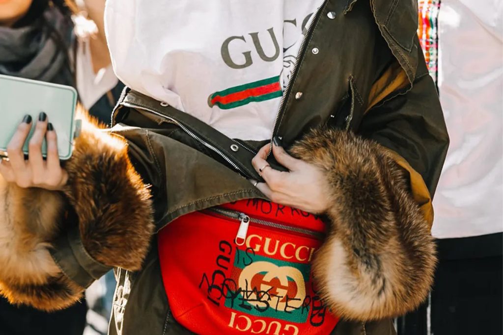 لوگوی برندهایی مثل گوچی در اوت-فیت اشخاص نیو مانی به چشم می‌خورد