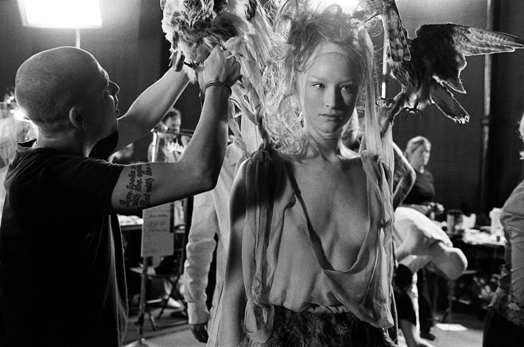 الکساندر مک‌ کوئین درحال فیکس کردن لباس در تن مدل